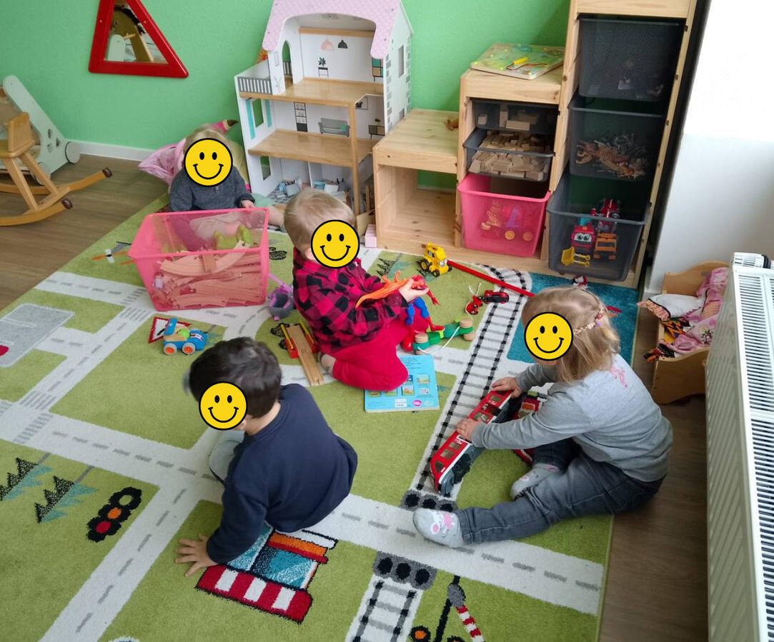 Hakuna Matata children at play inside. Hakuna Matata bilingual daycare reading children at play inside with cars and doll house.